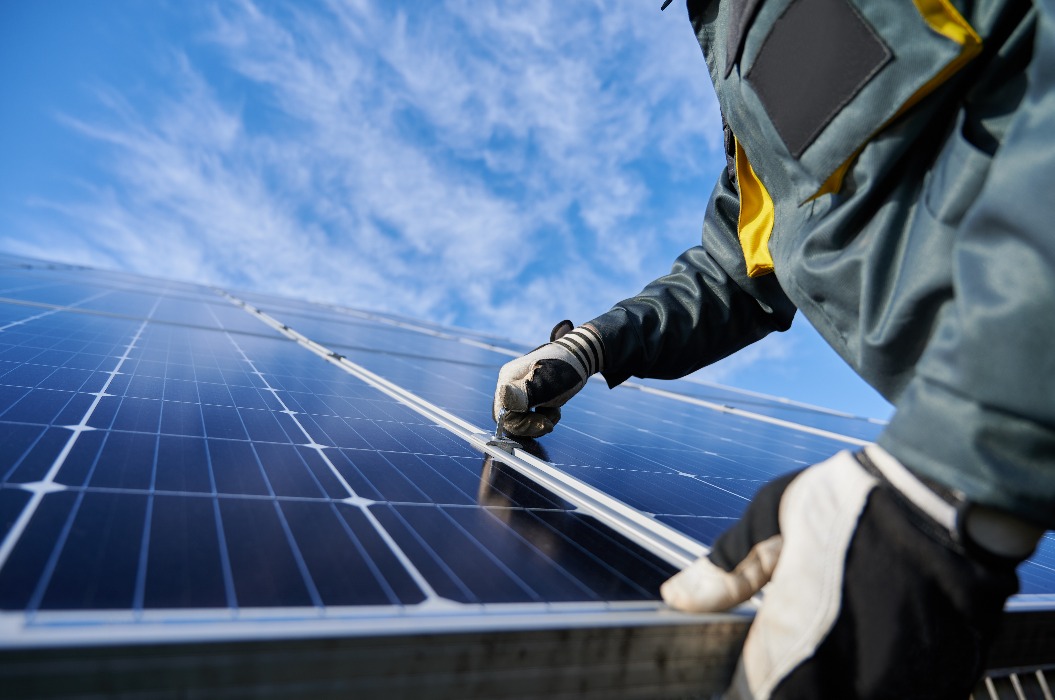 Ein Arbeiter repariert ein Photovoltaik-Solarmodul.