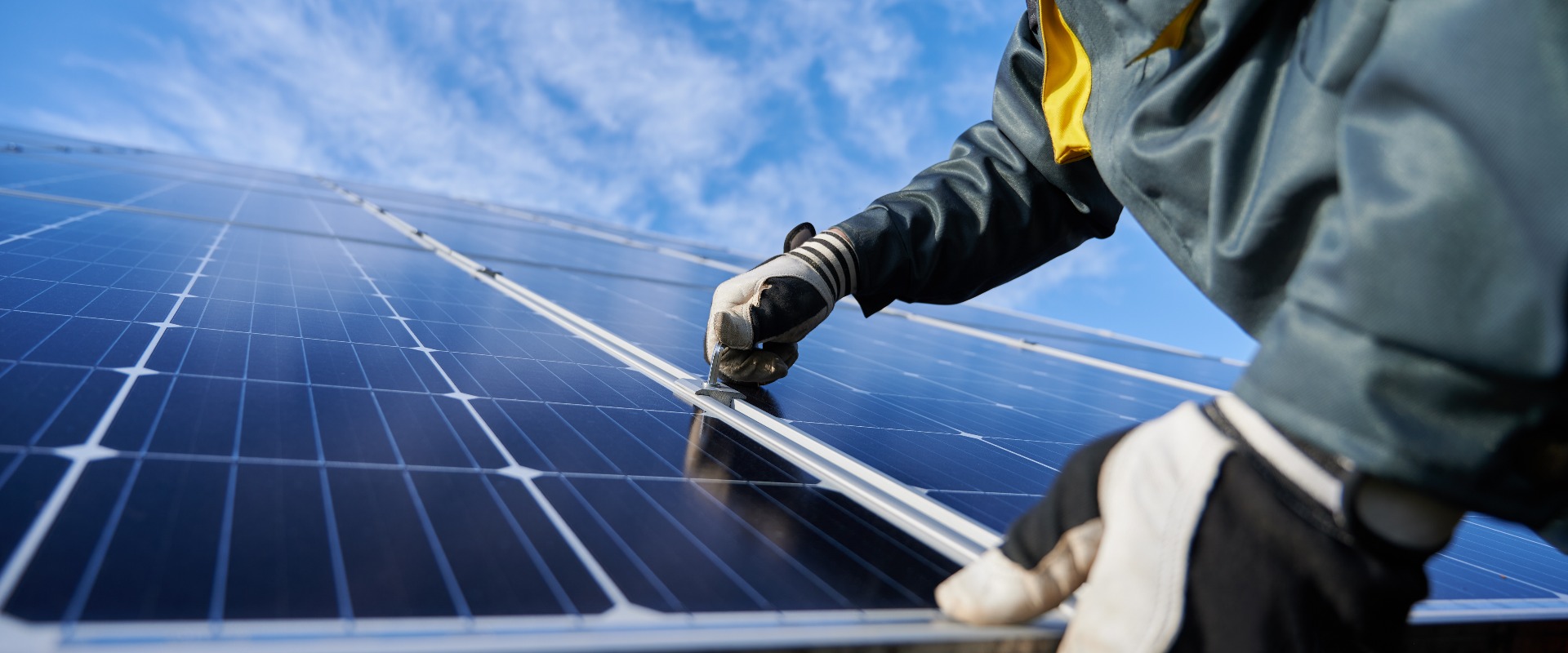 Ein männlicher Arbeiter repariert ein Photovoltaik-Solarmodul.
